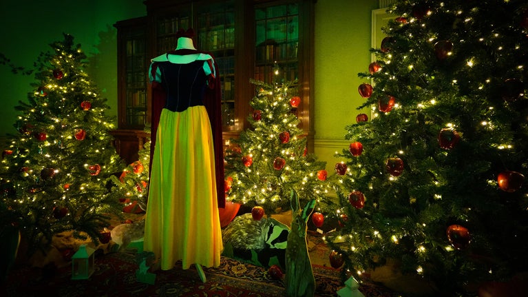 Snow White themed room with the famous dress and three Christmas trees decorated with shiny red apples
